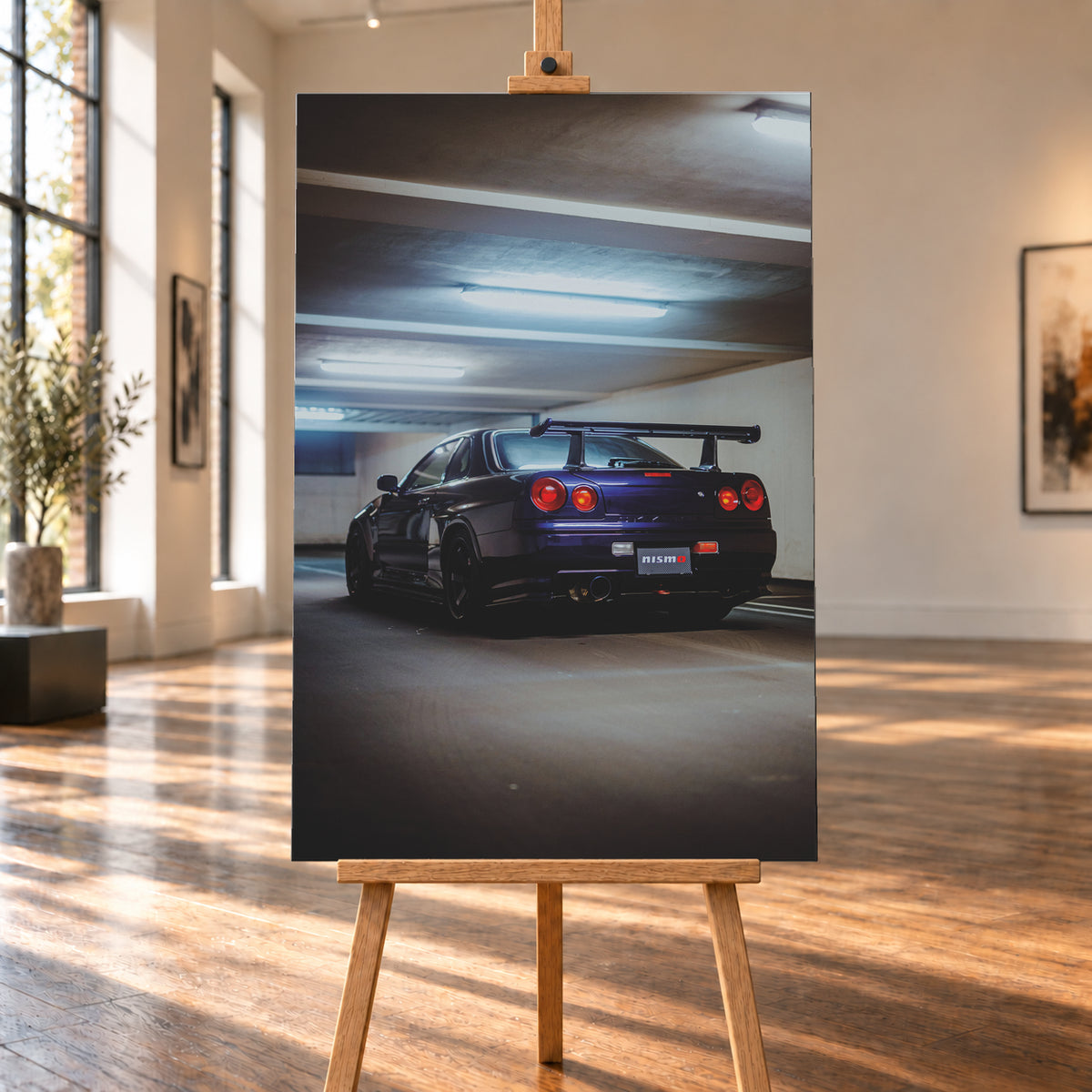 Dunkelvioletter Nissan Skyline R34 in tiefer Heckdreiviertelansicht in einem Parkhaus, mit vier runden roten Rückleuchten, großem Heckflügel, dunklen Rädern und kühlen Deckenleuchten; Visualisierung als Leinwand-Wandbild, auf einer Holzstaffelei in einem hellen Galerieraum.