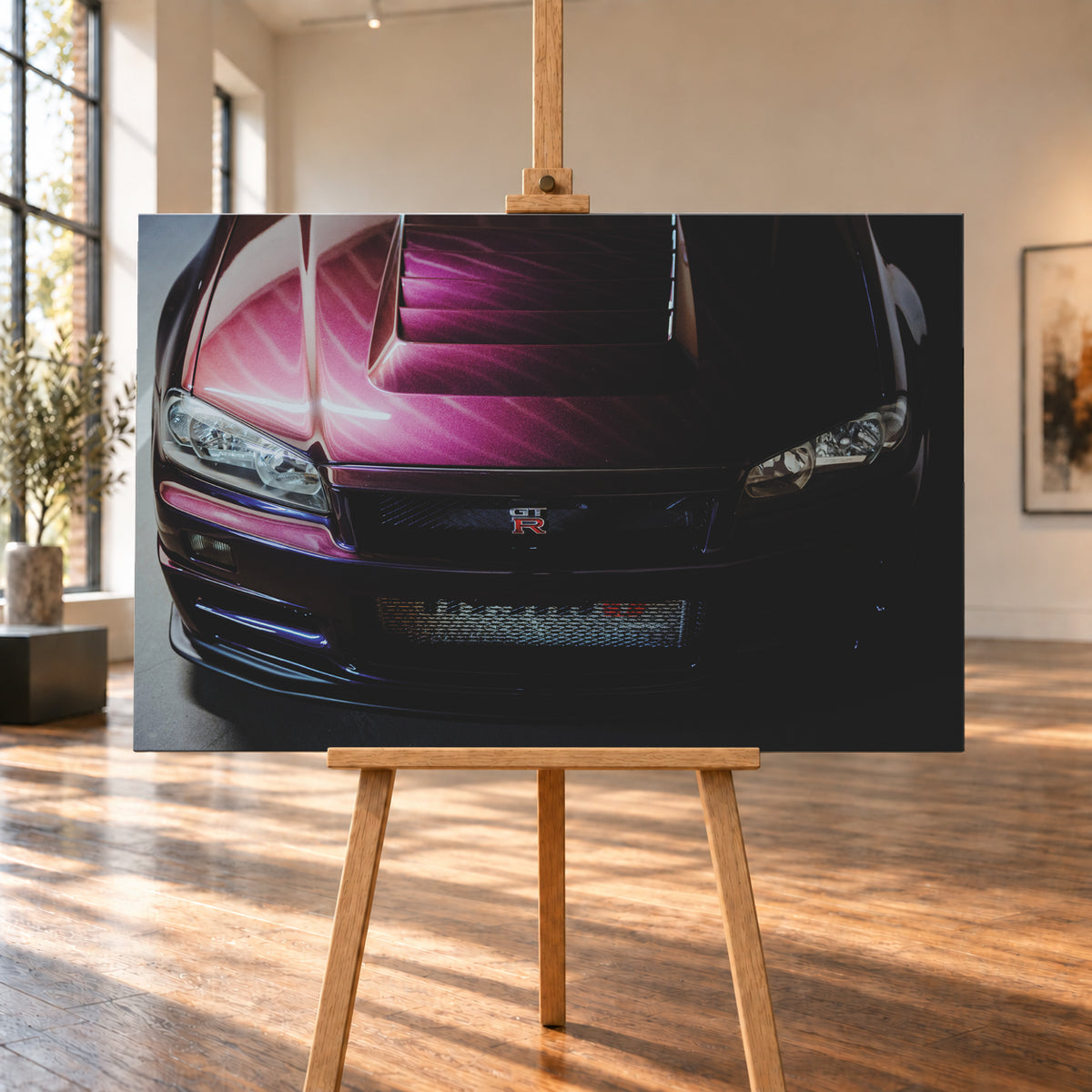 Enge Frontansicht eines dunkelvioletten Nissan Skyline R34 mit sichtbarem GT-R-Emblem, Haubenöffnungen und Scheinwerfern; magentafarbenes Licht links, tiefer Schatten rechts; Visualisierung als Leinwand-Wandbild, auf einer Holzstaffelei in einem hellen Galerieraum.