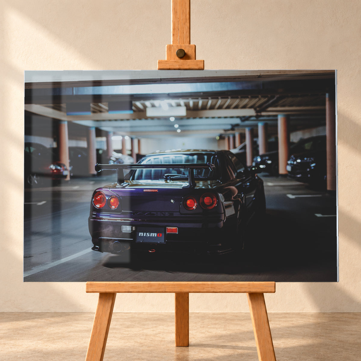 Heckansicht eines dunkelvioletten Nissan Skyline R34 mit großem Heckflügel und vier rot leuchtenden runden Rücklichtern auf einer überdachten Parkebene. Rötliche Säulen, Deckenbalken und unscharf abgestellte Fahrzeuge rahmen das Auto; kühles, gedämpftes Licht spiegelt sich auf der Karosserie; Visualisierung als Acrylglas-Wandbild, frontal auf einer Holzstaffelei.