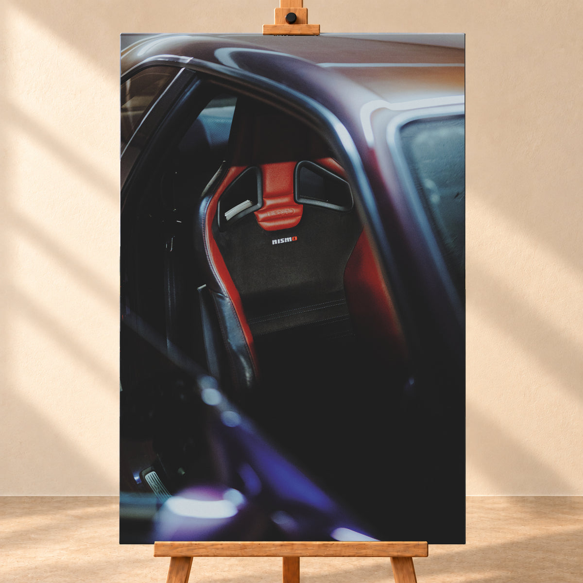 Nahaufnahme durch die geöffnete Tür eines violetten Nissan Skyline R34: Ein rot-schwarzer Sitz mit sichtbarem Nismo-Schriftzug steht im dunklen Innenraum; helle und blau-violette Reflexe verlaufen über Dachkante und Türrahmen; Visualisierung als Leinwand-Wandbild, frontal auf einer Holzstaffelei.