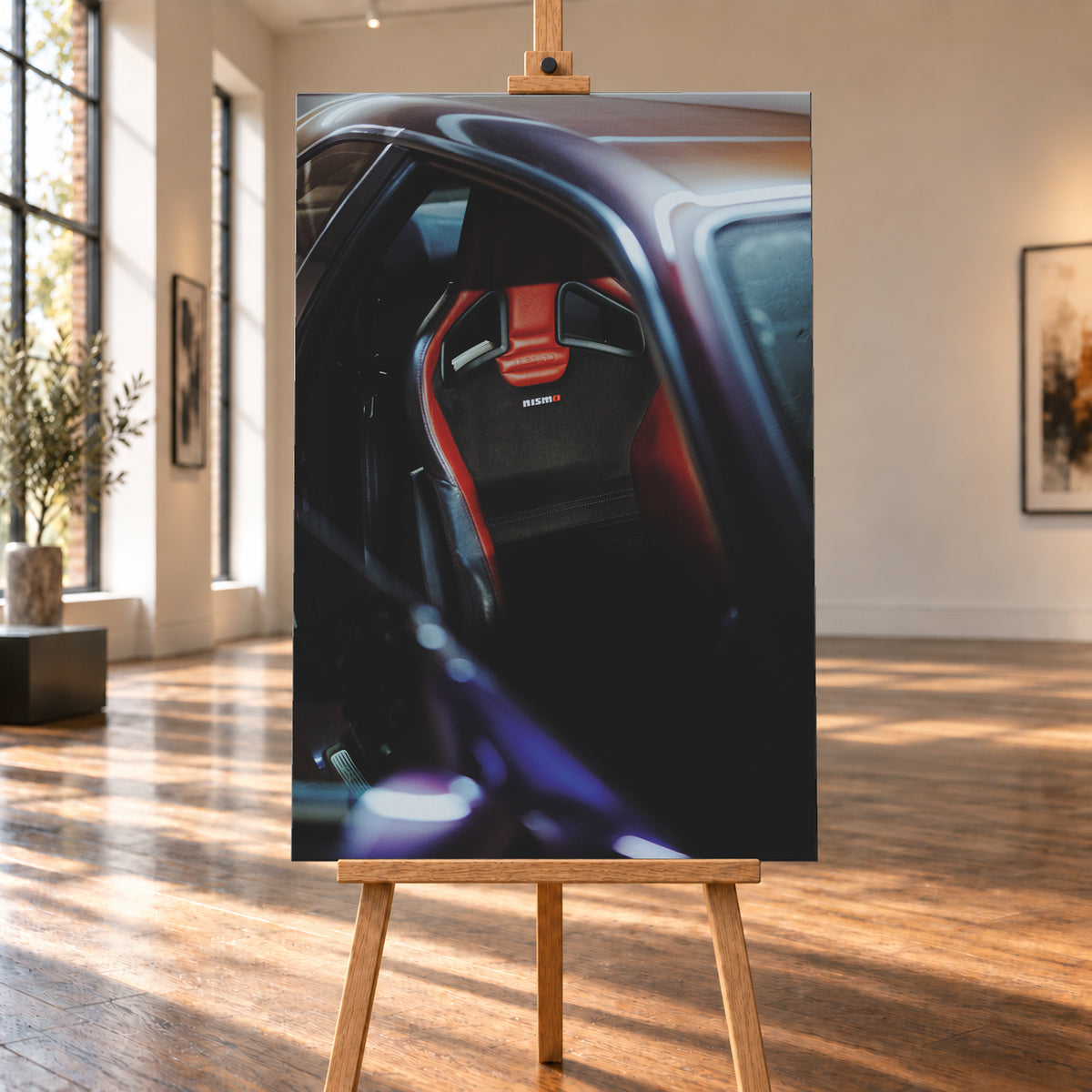 Nahaufnahme durch die geöffnete Tür eines violetten Nissan Skyline R34: Ein rot-schwarzer Sitz mit sichtbarem Nismo-Schriftzug steht im dunklen Innenraum; helle und blau-violette Reflexe verlaufen über Dachkante und Türrahmen; Visualisierung als Leinwand-Wandbild, auf einer Holzstaffelei in einem hellen Galerieraum.