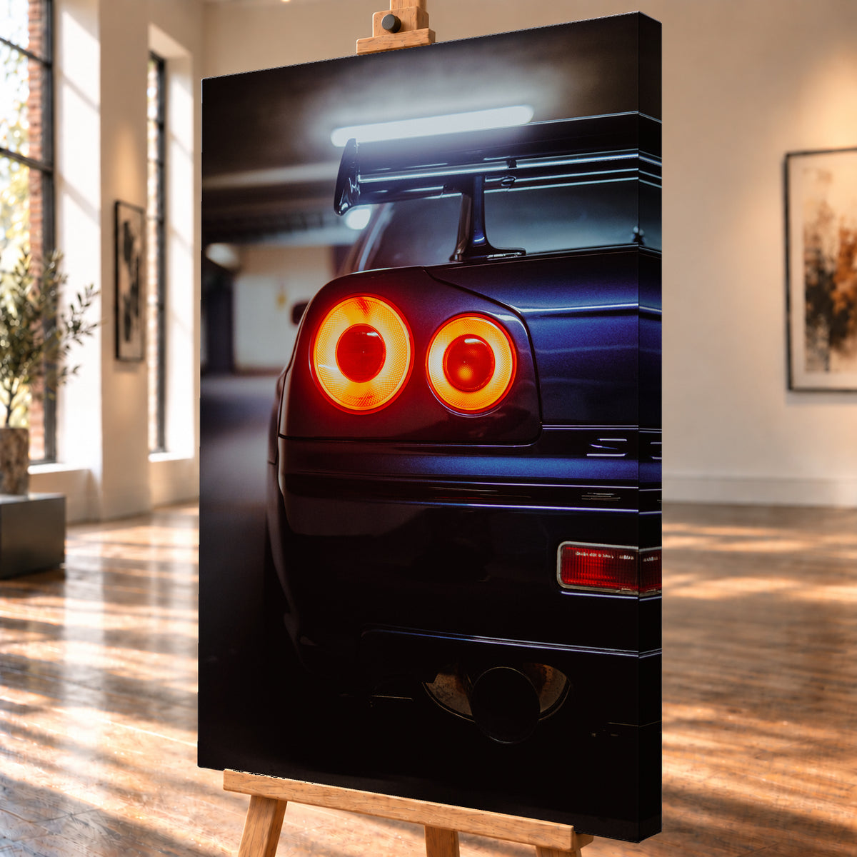 Nahaufnahme der Heckpartie eines dunklen Nissan Skyline R34 V-Spec mit zwei sichtbaren, rot-orange leuchtenden Rundrückleuchten, großem Heckflügel und rundem Auspuffendrohr vor unscharfem, kühl beleuchtetem Hintergrund; Visualisierung als Leinwand-Wandbild, schräg von der Seite auf einer Holzstaffelei.