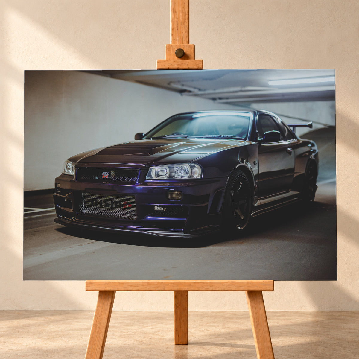 Dunkelvioletter Nissan Skyline R34 in Front-Dreiviertelansicht auf einem Parkdeck, mit schwarzem Kühlergrill, dunklen Rädern und großem Heckflügel. Helle Deckenleuchten spiegeln sich auf Motorhaube, Windschutzscheibe und Dach; Betonwand und Bodenmarkierungen rahmen das Fahrzeug; Visualisierung als Leinwand-Wandbild, frontal auf einer Holzstaffelei.