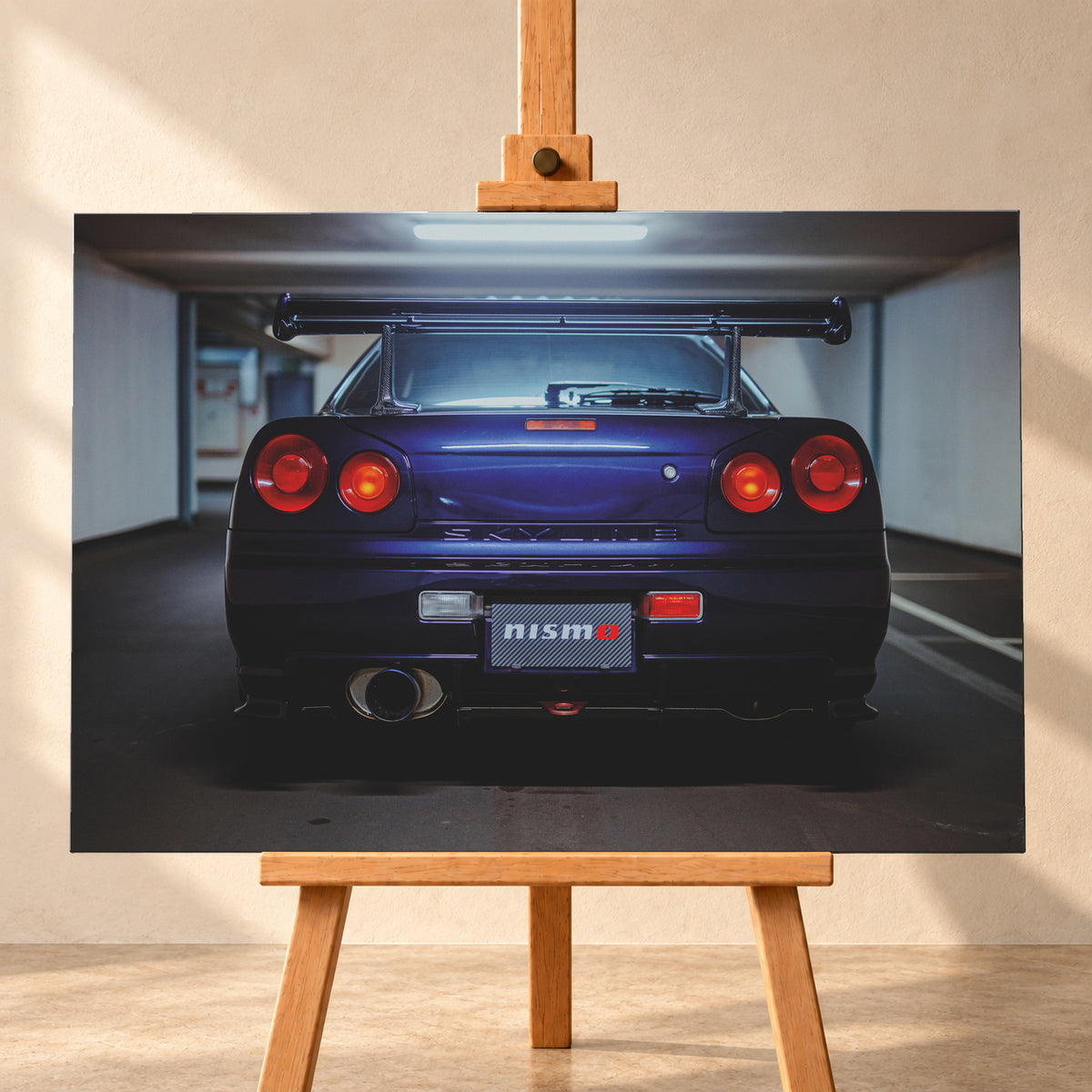 Zentrierte Heckansicht eines dunkelvioletten Nissan Skyline R34 in einer Parkgarage. Sichtbar sind vier runde rote Rückleuchten mit orangefarbenen inneren Leuchtelementen, ein großer Heckflügel, ein breites Auspuffendrohr links, ein Nismo-Schriftzug und kühles Deckenlicht über dem Fahrzeug; Visualisierung als Leinwand-Wandbild, frontal auf einer Holzstaffelei.