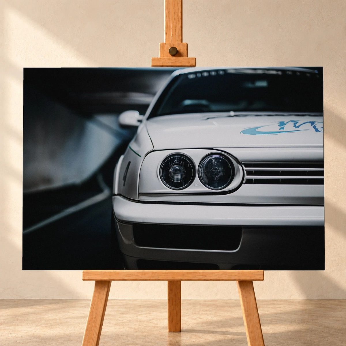 Visualisierung einer querformatigen Leinwand auf einer Holzstaffelei vor heller Wand. Das Motiv zeigt die Front von Jesses weißem VW Jetta aus „The Fast and the Furious“ mit runden Doppelscheinwerfern und blauer Grafik auf der Motorhaube.
