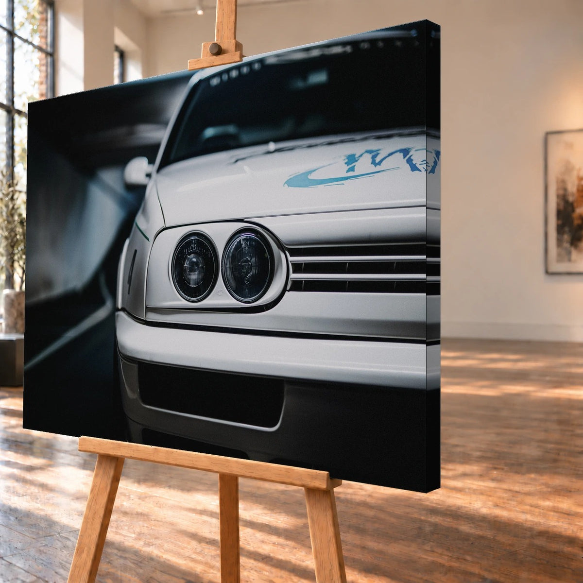 Schrägansicht einer Leinwand als Produktvisualisierung auf einer Holzstaffelei, mit sichtbar bedruckter rechter Seitenkante. Jesses weißer VW Jetta ist im Frontdetail mit runden Doppelscheinwerfern, Kühlergrill und blauer Haubengrafik abgebildet.