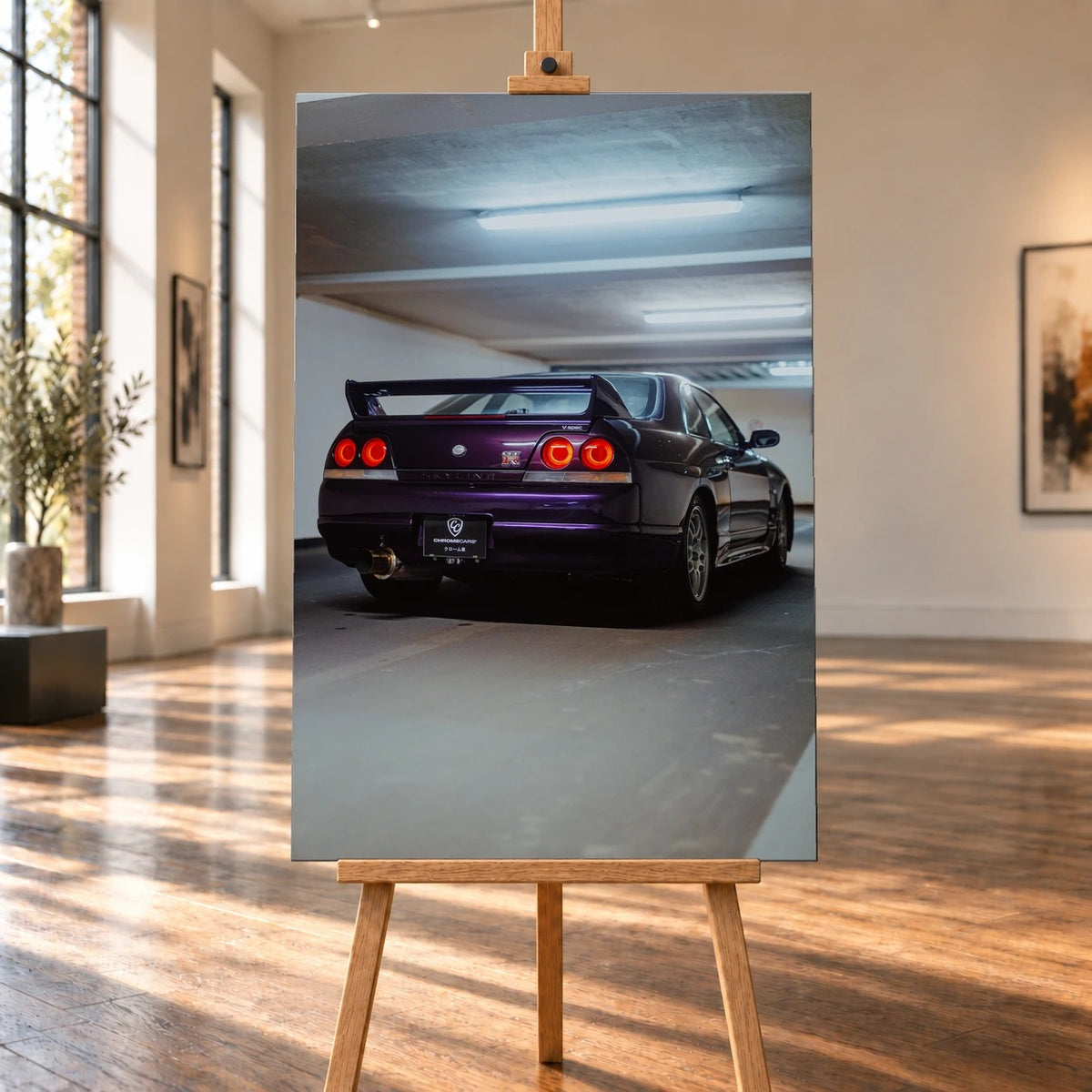 Raumvisualisierung eines hochformatigen Leinwandbilds auf einer Holzstaffelei in einem sonnigen Raum mit hohen Fenstern und Holzboden. Das Bild zeigt einen violetten Nissan Skyline GT-R R33 V-Spec von schräg hinten in einer Garage.