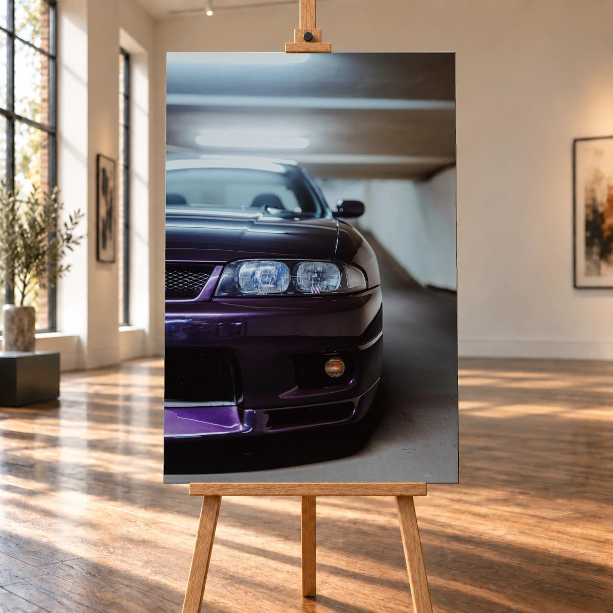 Raumvisualisierung eines hochformatigen Leinwandbildes auf einer Holzstaffelei in einem sonnigen Galerieraum mit Holzboden. Das Bildmotiv zeigt eine Nahaufnahme der violetten Front eines Nissan Skyline R33 V-Spec.
