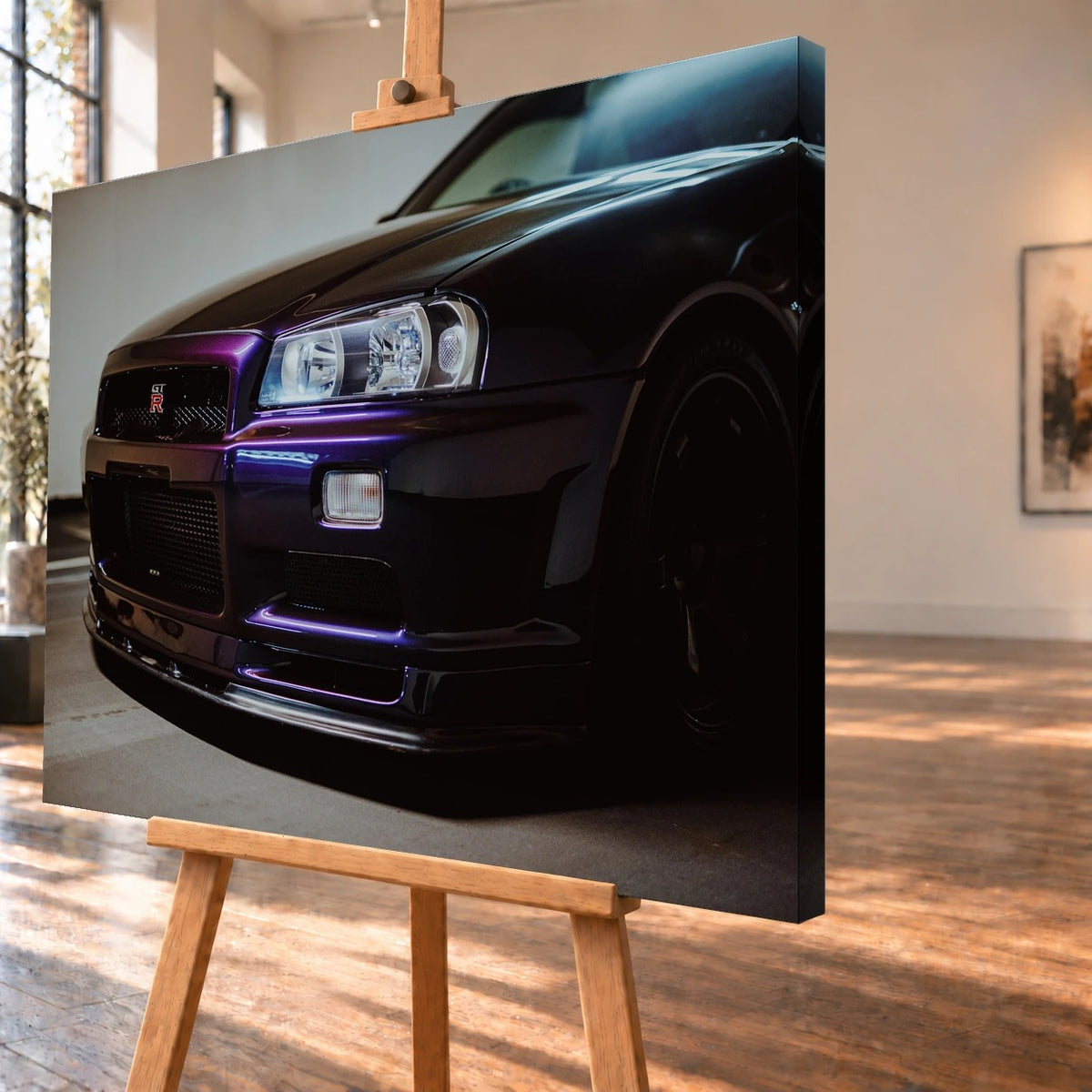 Schrägansicht eines Leinwandbilds als Produktvisualisierung auf einer Holzstaffelei. Die rechte Seitenkante ist deutlich sichtbar; auf dem Motiv setzen violette Lichtreflexe die Front eines Nissan Skyline GT-R R34 mit großem Scheinwerfer in Szene.