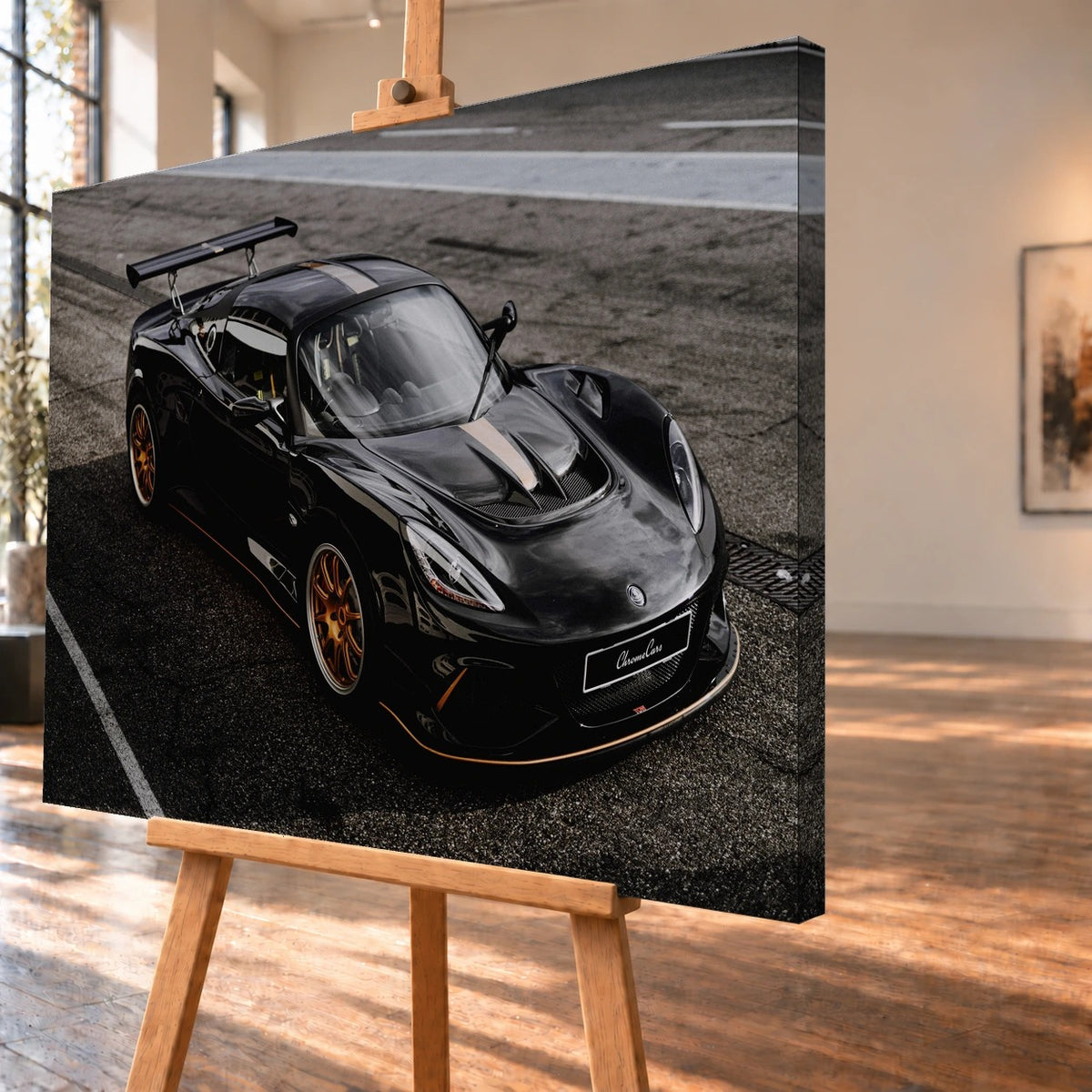Schrägansicht eines als Leinwandbild visualisierten Lotus Exige 430 Cup Type 79 auf einer Holzstaffelei. Die bedruckte rechte Seitenkante ist sichtbar; das Motiv zeigt den schwarzen Sportwagen mit goldfarbenen Felgen auf Asphalt.