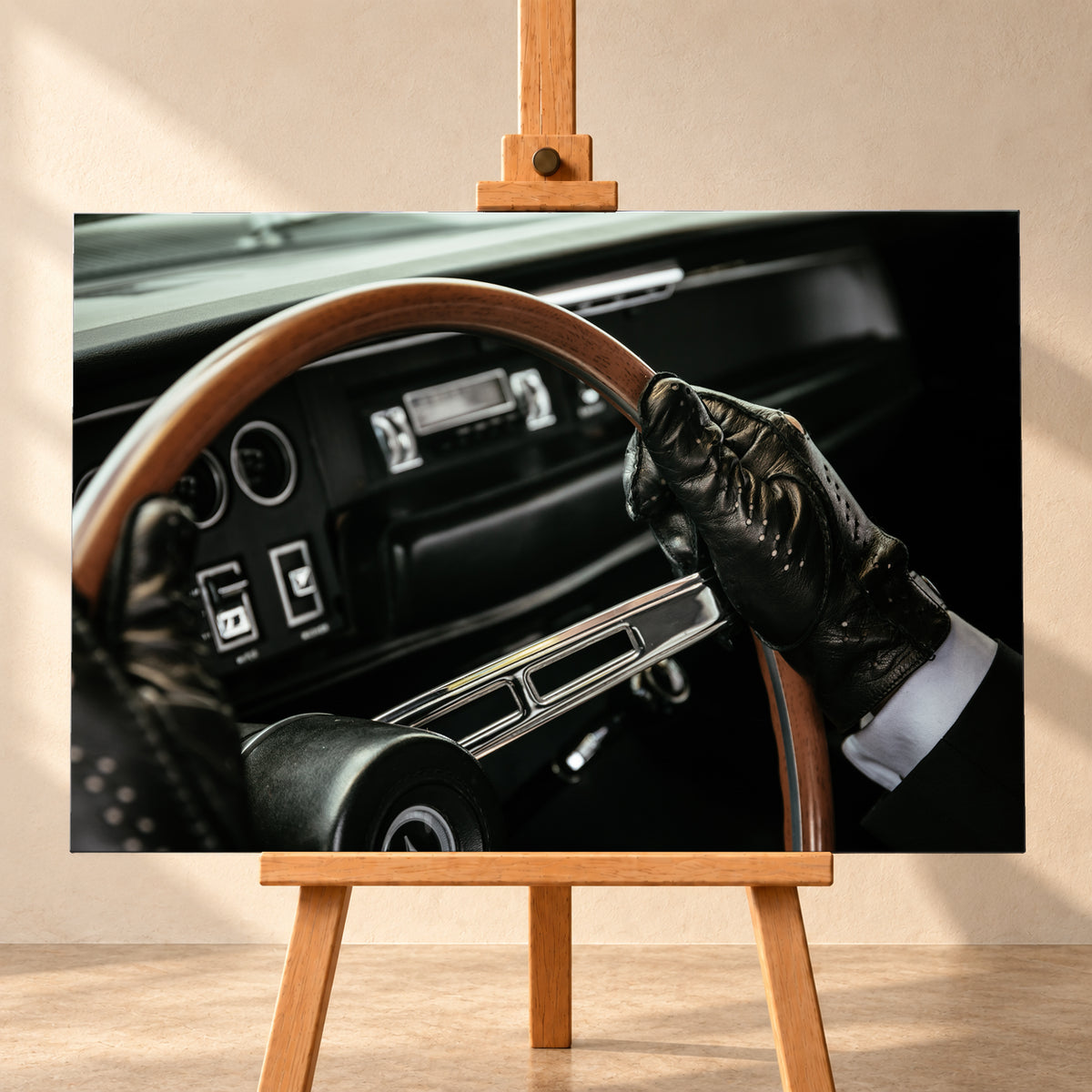 Nahaufnahme eines dunklen Fahrzeugcockpits: Eine Hand in schwarzem, perforiertem Handschuh greift ein braunes, holzfarbenes Lenkrad. Rundinstrumente, Radio und Armaturenbrett liegen unscharf im Hintergrund; seitliches Licht hebt Handschuh, Lenkradkranz und metallisch glänzende Speiche hervor; Visualisierung als Leinwand-Wandbild, frontal auf einer Holzstaffelei.