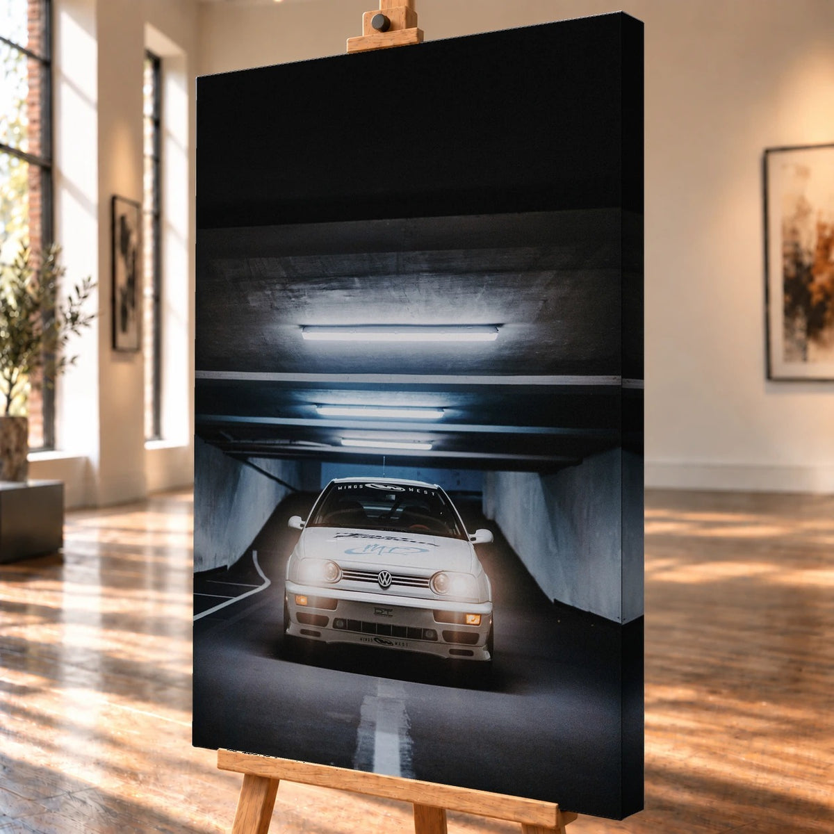 Schrägansicht einer visualisierten Leinwand auf einer Holzstaffelei mit deutlich sichtbarer rechter Seitenkante. Der weiße VW Jetta aus „The Fast and the Furious“ ist im Motiv frontal unter den Leuchtstoffröhren einer Tiefgarage zu sehen.