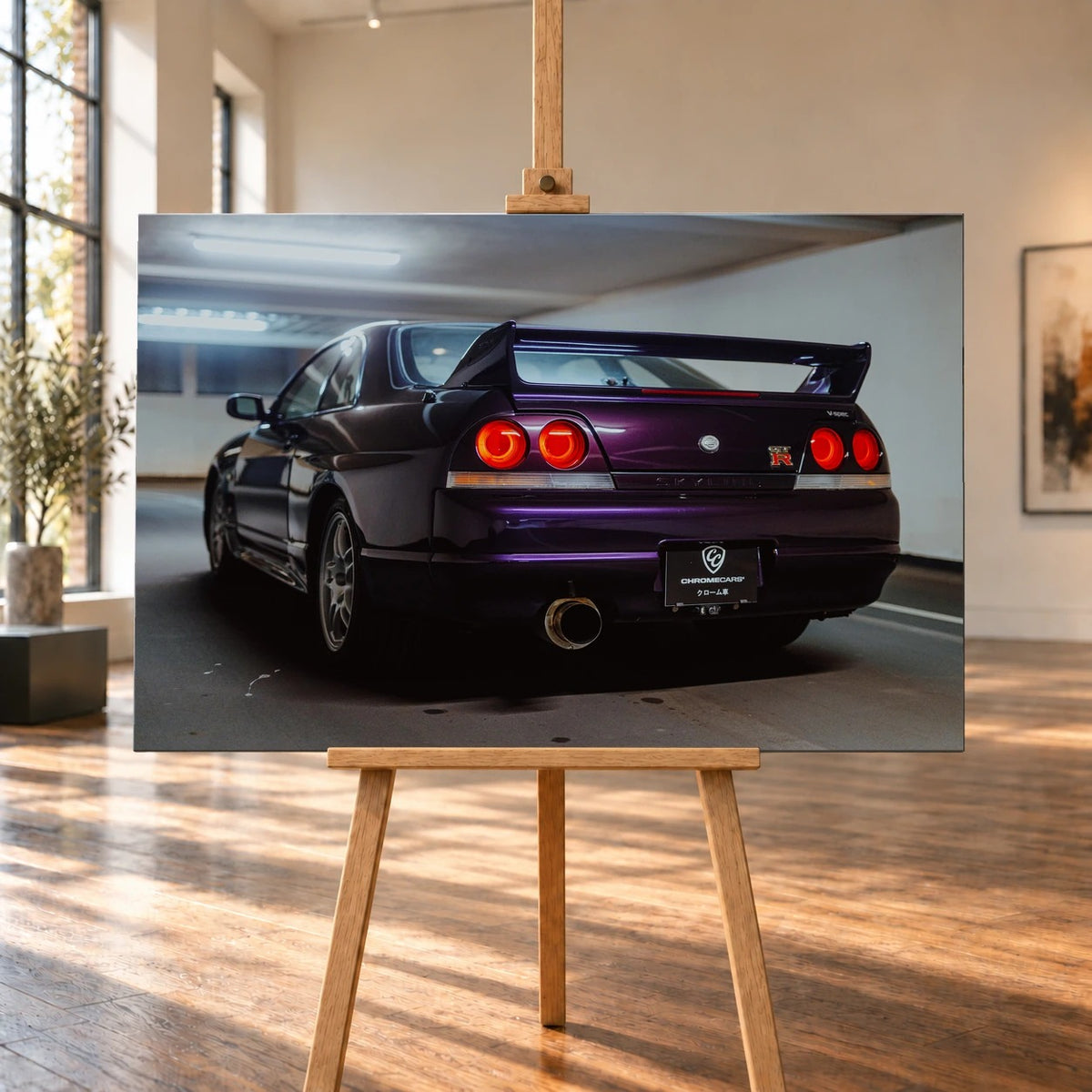 In einem hellen Raum mit hohen Fenstern und Holzboden wird ein Leinwandbild auf einer Holzstaffelei visualisiert. Es zeigt einen violetten Nissan Skyline GT-R R33 V-Spec in Heckansicht mit großem Flügel und roten runden Rückleuchten.