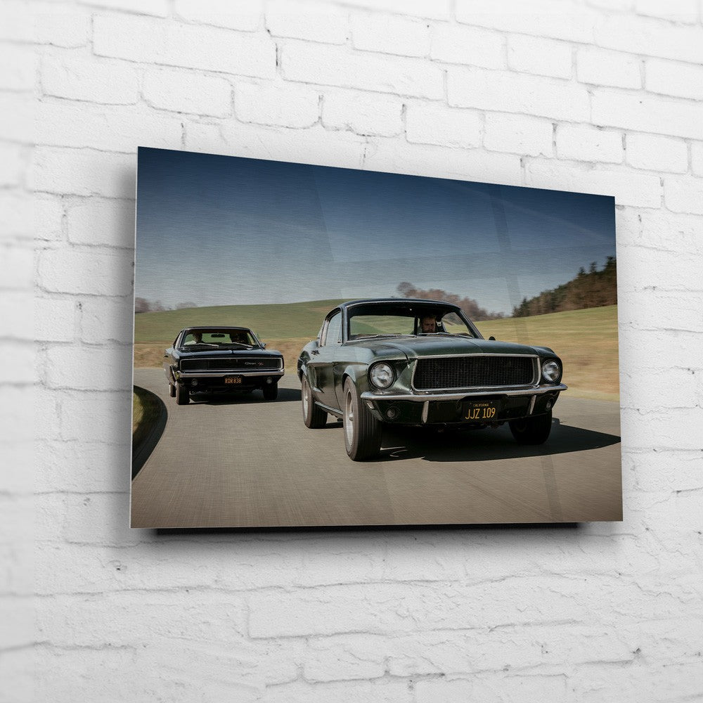 Bullitt Charger – Side-by-Side Chase auf gebürstetem Aluminium an weißer Ziegelwand