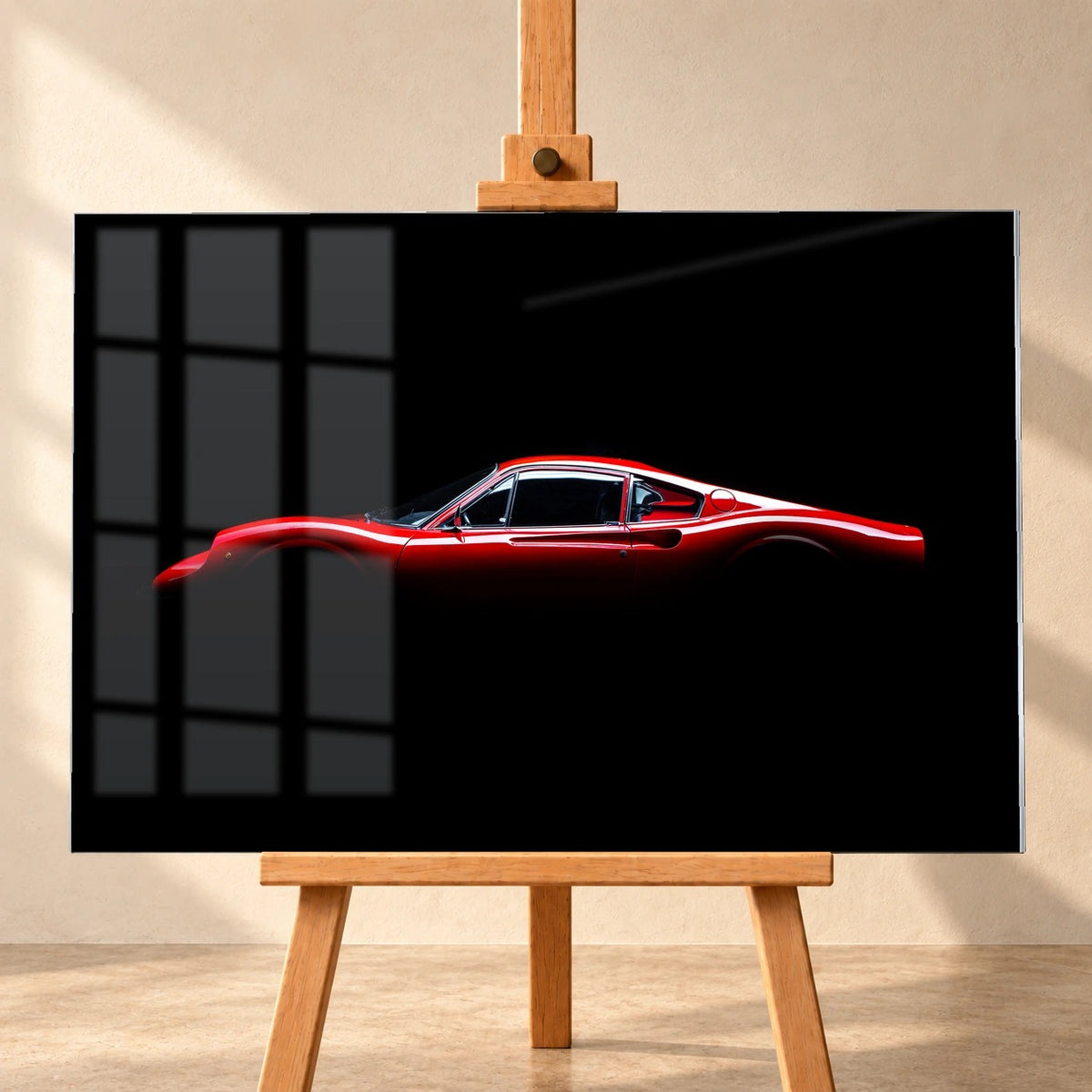 Frontale Visualisierung eines Acrylglasbildes auf einer Holzstaffelei: ein roter Ferrari GT 246 in Seitenansicht vor Schwarz. Dargestellte Fensterreflexionen überlagern die linke Bildseite.