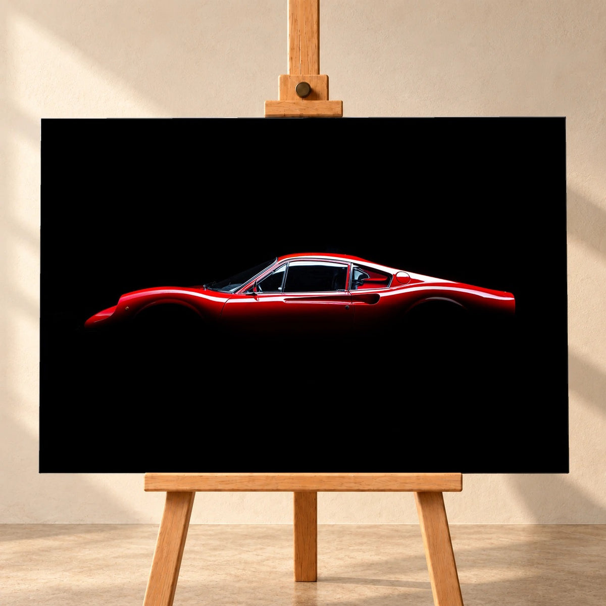 Visualisierung eines querformatigen Leinwandbildes auf einer Holzstaffelei vor heller Wand. Das Motiv zeigt einen roten Ferrari GT 246 im Seitenprofil nach links vor schwarzem Hintergrund.
