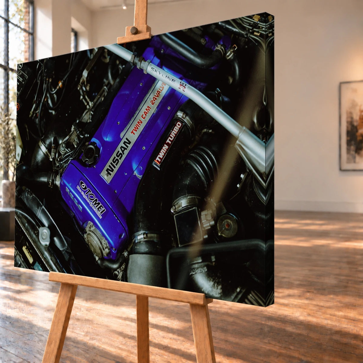 Leinwandbild in schräger Ansicht als Produktvisualisierung auf einer Holzstaffelei, mit sichtbarer bedruckter Seitenkante rechts. Im Motorraummotiv eines Nissan Skyline R33 hebt sich der violette Ventildeckel von den schwarzen Schläuchen ab.