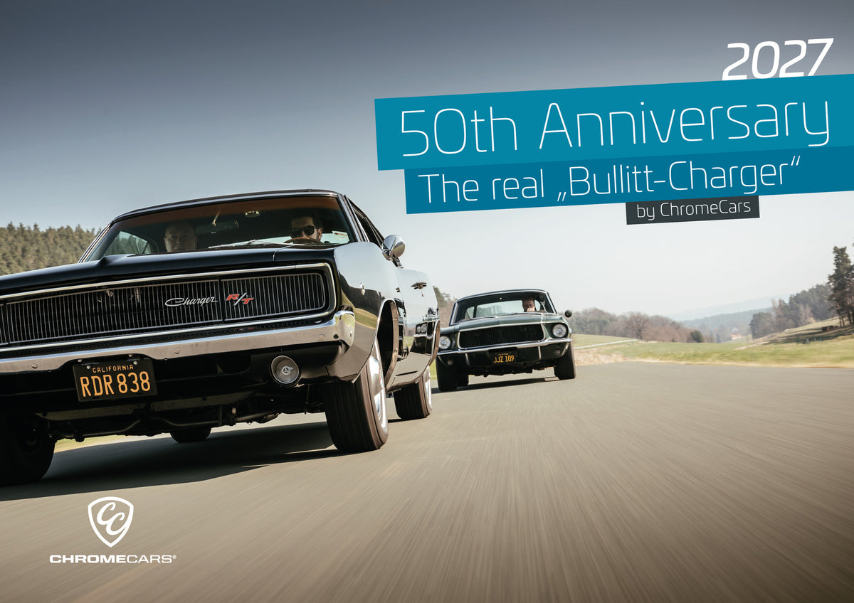 Bullitt Kalender 2027 – Deckblatt: Schwarzer Dodge Charger R/T aus tiefer Frontperspektive auf einer Landstraße; dahinter folgt ein zweites dunkles klassisches Coupé. Heller Himmel, Felder und Bäume umgeben die Straße…