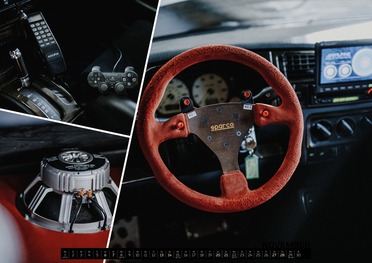 Jesse’s Jetta Kalender 2027 – November: Eine Bildkomposition vereint folgende Ansichten: Die dunkle Cockpitaufnahme konzentriert sich auf Automatik-Wählhebel, Bedieneinheit und PlayStation-Controller; Ein metallischer…