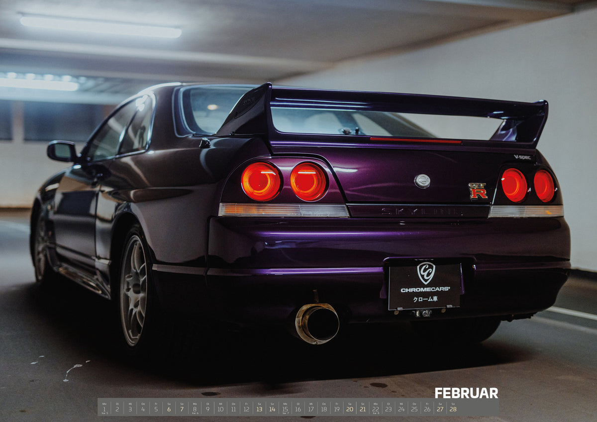 Midnight Purple I Kalender 2027 – Februar: Die tiefe Dreiviertel-Heckansicht des Nissan Skyline R33 zeigt Rundlichter, Spoiler und großes Endrohr vor einer hellen Betonwand