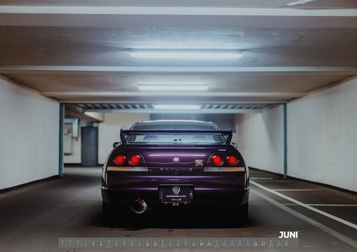 Midnight Purple I Kalender 2027 – Juni: Der Nissan Skyline R33 steht mittig von hinten in einer leeren Parkhausachse; seine vier Rundlichter leuchten vor kühlem Beton
