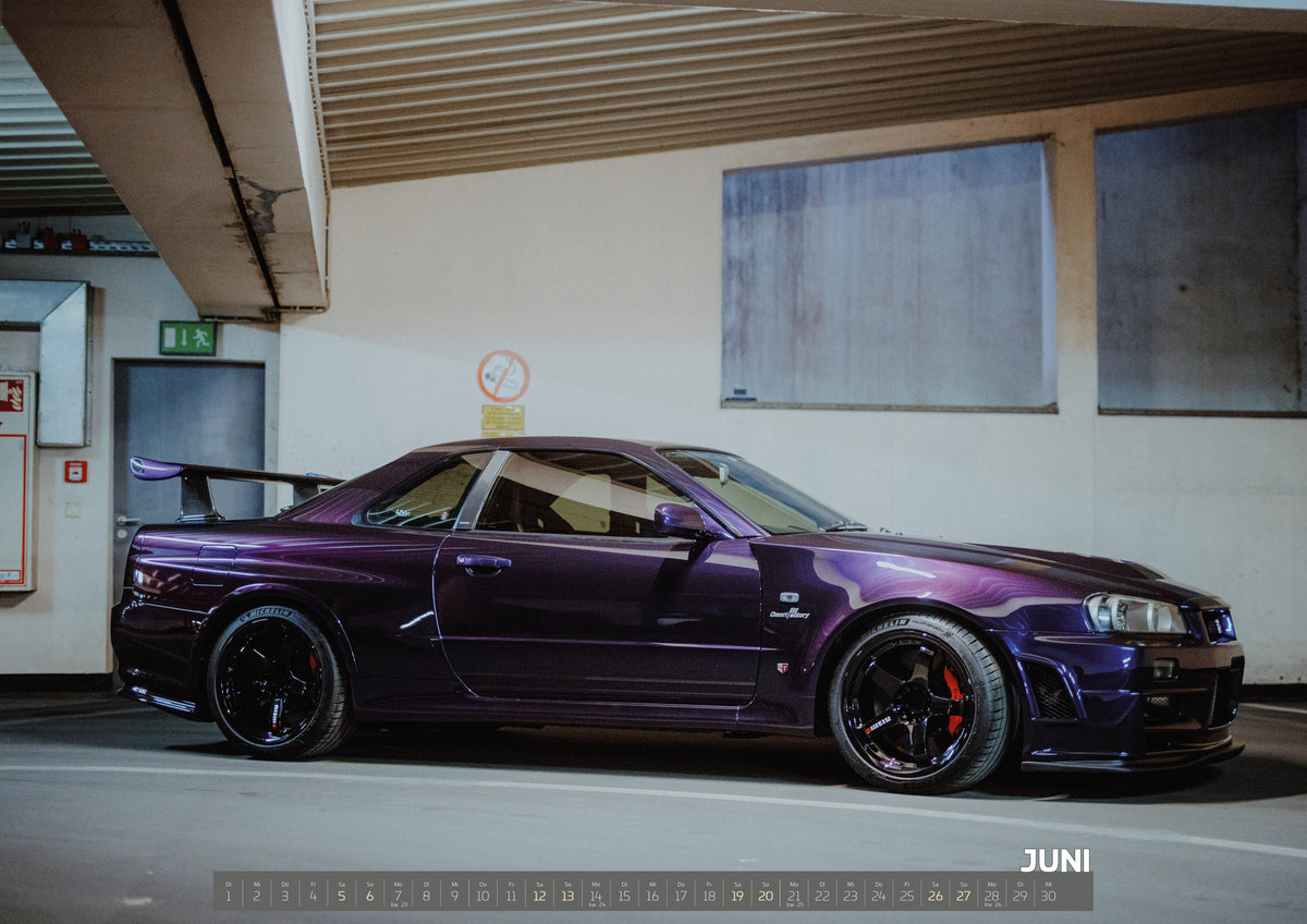 Midnight Purple Collection Kalender 2027 – Juni: Violetter Nissan Skyline R34, nahezu seitlich mit der Front nach rechts, in einem hellen Parkgaragen-Innenraum; sichtbar sind schwarze Räder, rote Bremssättel und ein großer Heckflügel