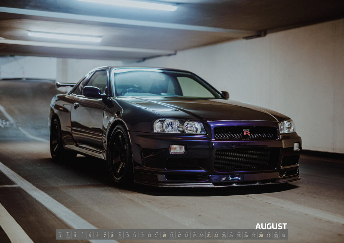 Midnight Purple Collection Kalender 2027 – August: Der Nissan Skyline R34 steht schräg von vorn an einer weißen Parkhauskurve; breite Front und violette Reflexe bilden den Blickfang