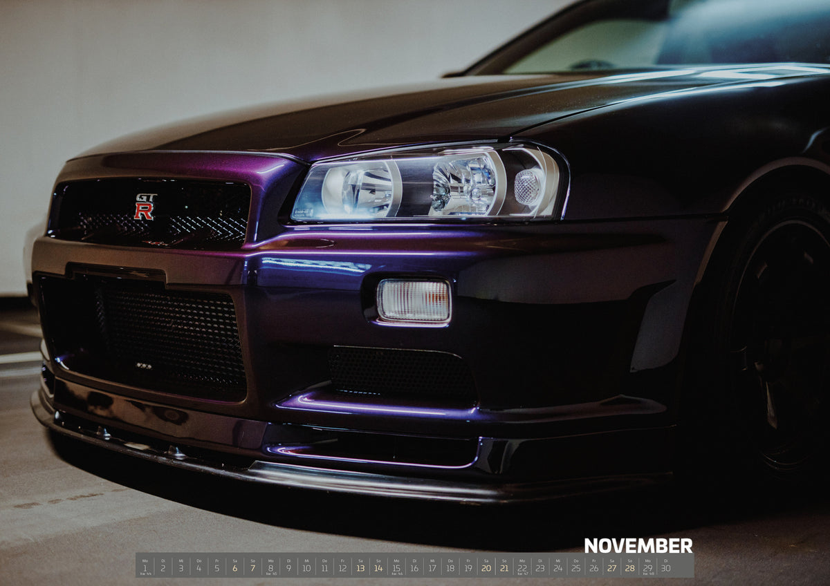 R34 Midnight Purple II Kalender 2027 – November: Die tiefe Nahaufnahme des Nissan Skyline R34 konzentriert sich auf Scheinwerfer, Grill und violette Frontschürze