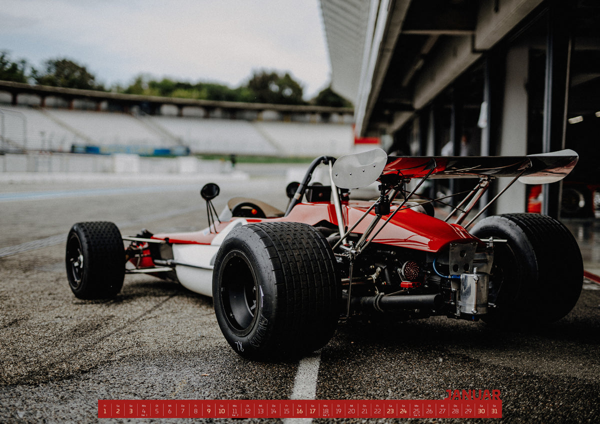 Trackday Kalender 2027 – Januar: Der rot-weiße Lotus 69 Formel 2 steht schräg von hinten in der Boxengasse; offene Räder und filigranes Heck prägen die Aufnahme