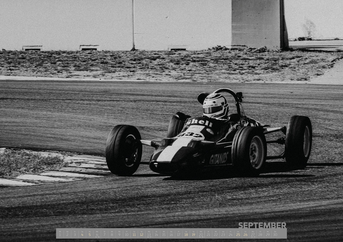 Trackday Kalender 2027 – September: Ein historischer offener Rennwagen fährt in Schwarz-Weiß durch eine Kurve; Fahrer, schmale Reifen und körnige Bildwirkung erinnern an klassische Rennfotografie