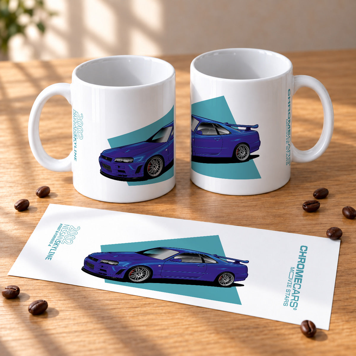 Zwei weiße Tassen mit blauem Nissan-Skyline-R34-Motiv; davor liegt ein Blatt mit der vollständigen Gestaltung.