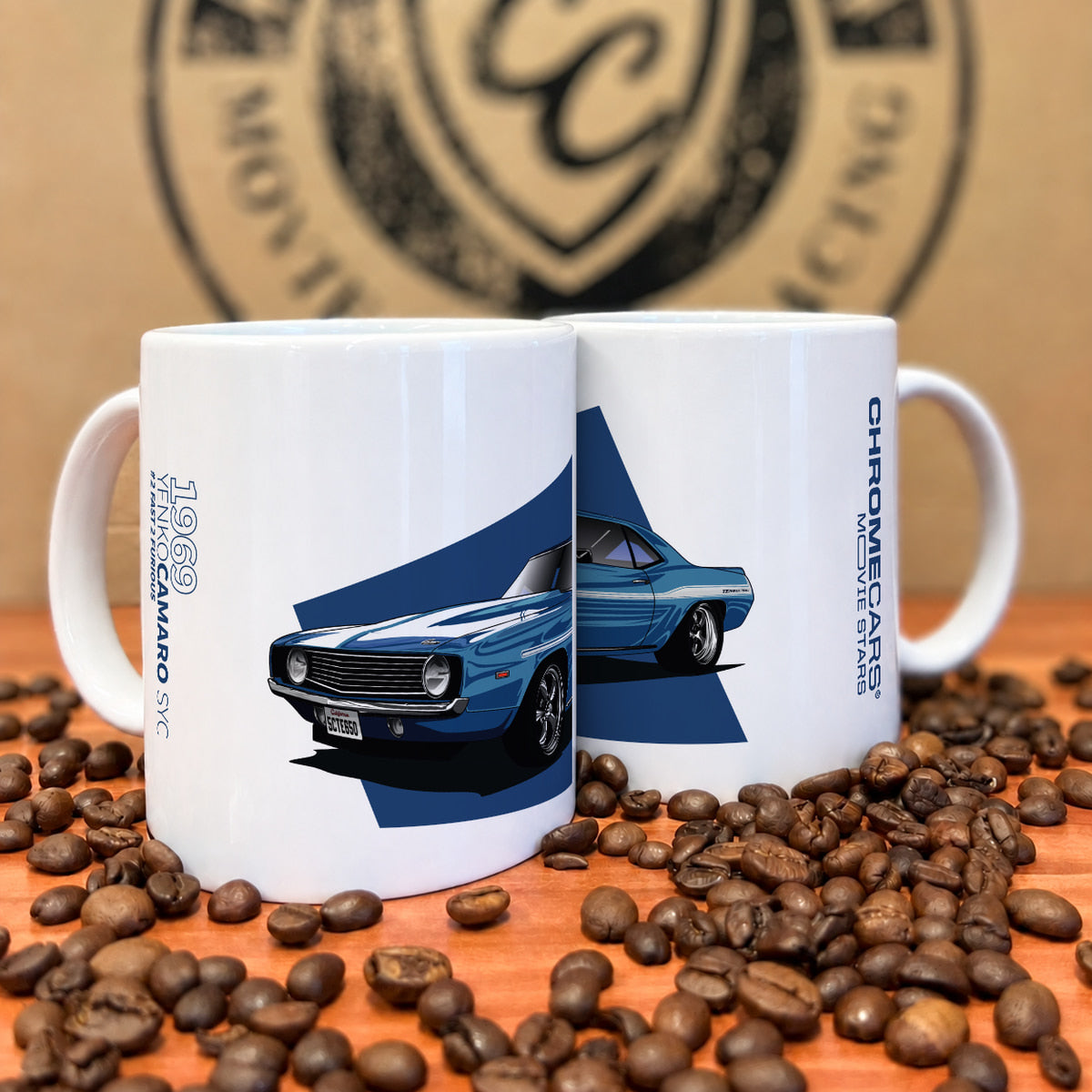 Zwei weiße Tassen mit Yenko-Camaro-Druck zwischen Kaffeebohnen.