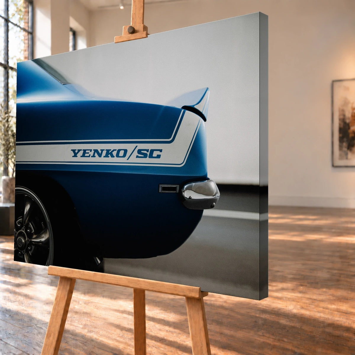 Schrägansicht des Leinwandbilds als Visualisierung auf einer Holzstaffelei, mit deutlich sichtbarer rechter Seitenkante. Im Motiv trägt die blaue Heckpartie des Chevrolet Camaro Yenko einen weißen „YENKO/SC“-Streifen.