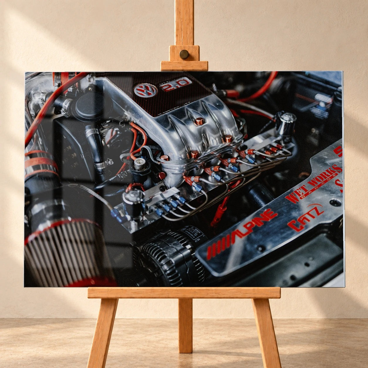 Frontal visualisiertes Acrylglasbild auf einer Holzstaffelei vor heller Wand. Fensterspiegelungen liegen über dem Motorraummotiv von Jesses VW Jetta aus „The Fast and the Furious“ mit silberner Ansaugbrücke und roten Leitungen.