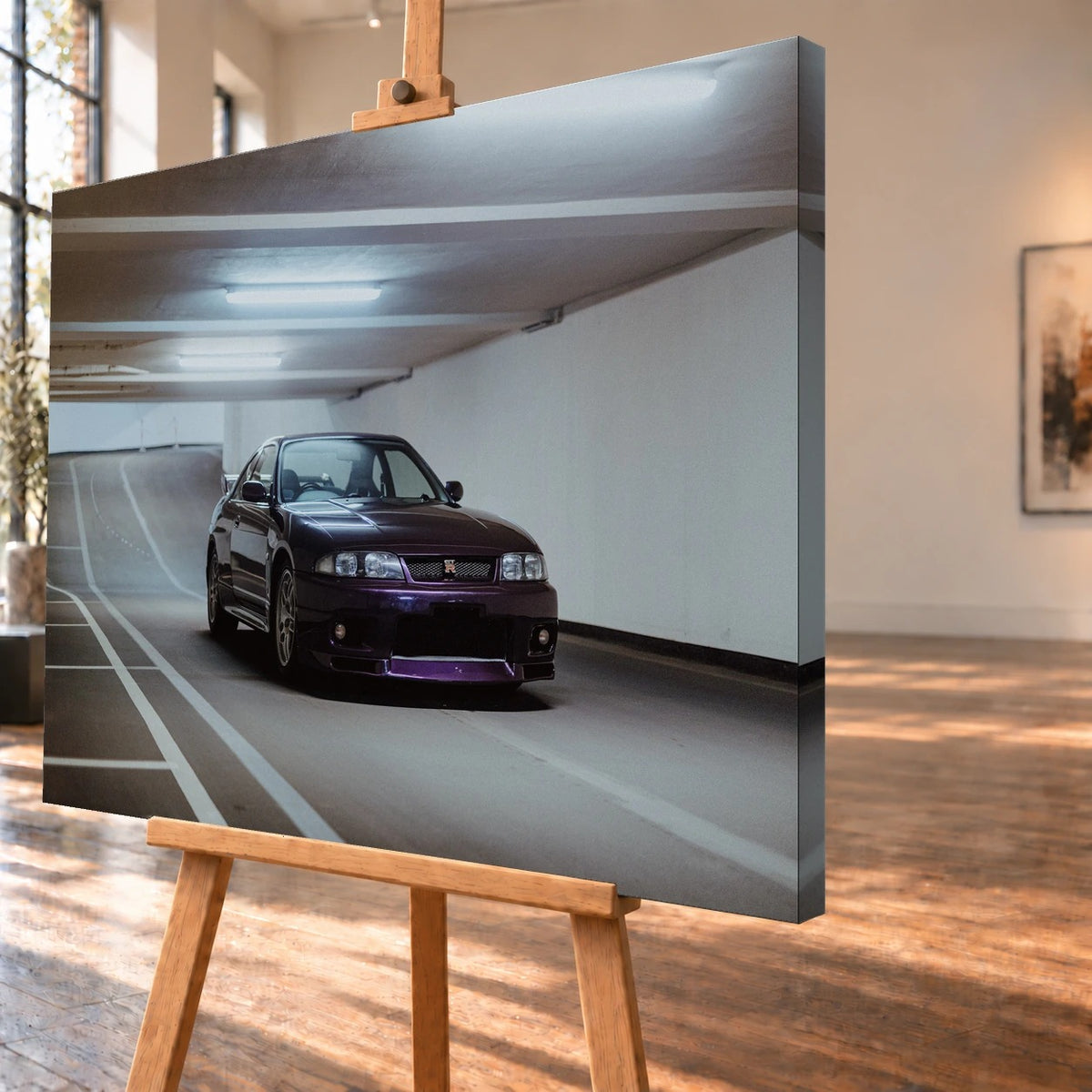 Schrägansicht eines Leinwandbilds als Visualisierung auf einer Holzstaffelei, mit deutlich sichtbarer rechter Seitenkante. Auf dem Bild steht ein dunkelvioletter Nissan Skyline GT-R R33 unter den Deckenleuchten einer Tiefgarage.