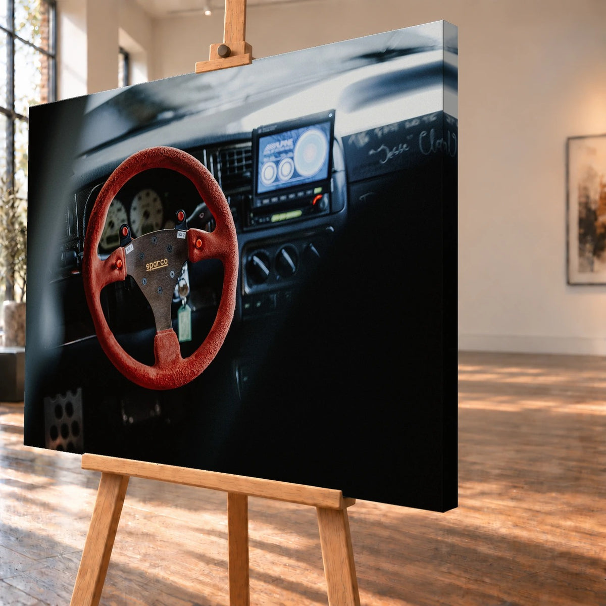 Schrägansicht eines visualisierten Leinwandbildes auf einer Staffelei, mit sichtbarer bedruckter rechter Seitenkante. Im Motiv steht das rote Sparco-Lenkrad im Cockpit von Jesses VW Jetta aus „The Fast and the Furious“ im Vordergrund.