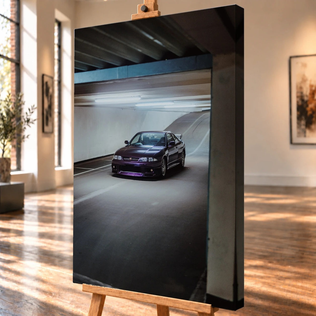 Schrägansicht eines visualisierten Leinwandbildes auf einer Holzstaffelei mit deutlich sichtbarer rechter Seitenkante. Auf dem hochformatigen Motiv steht ein dunkelvioletter Nissan Skyline GT-R R33 unter den Leuchtstoffröhren eines Parkhauses.