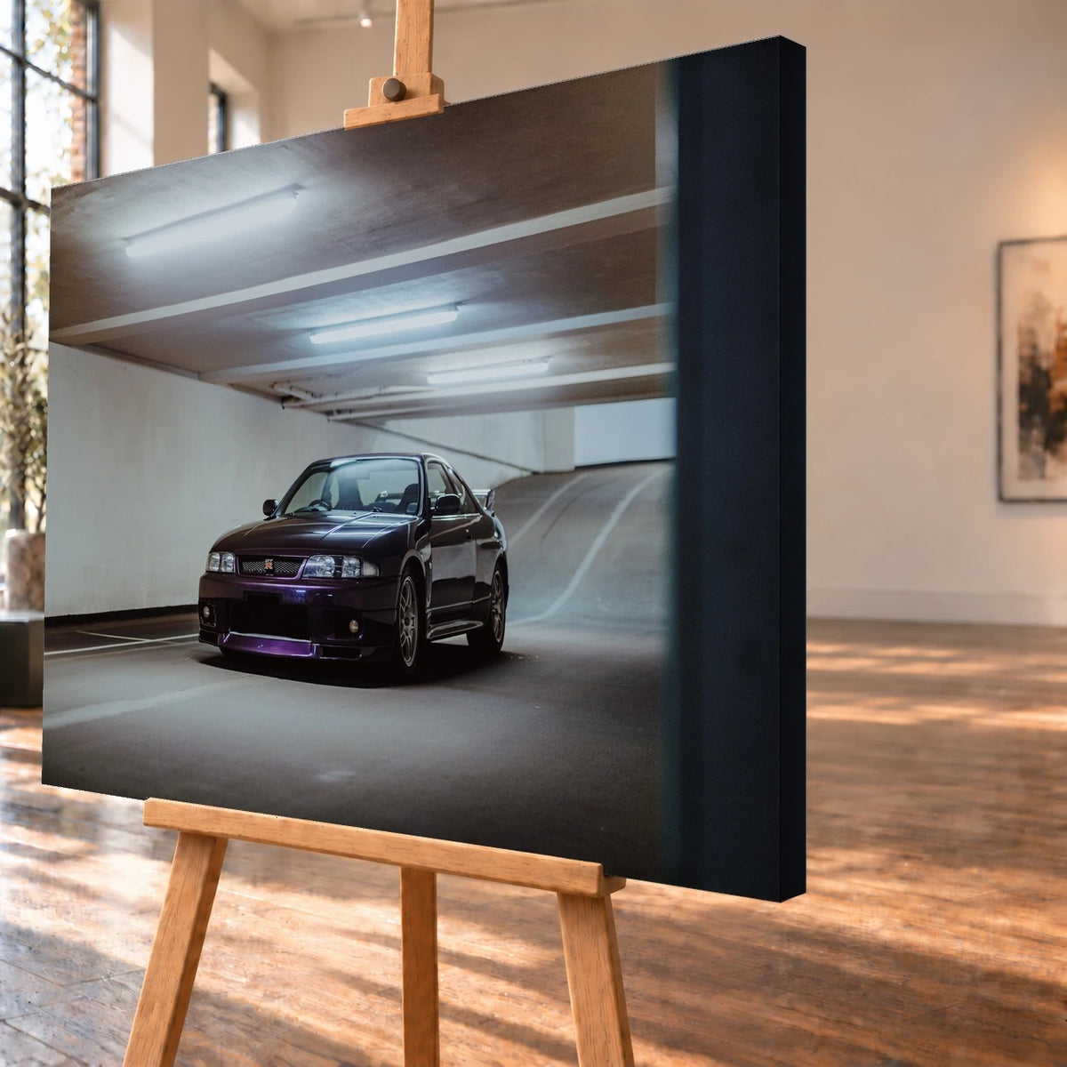 Schrägansicht eines Leinwandbilds als Visualisierung auf einer Holzstaffelei, mit deutlich sichtbarer dunkler Seitenkante rechts. Auf dem Bild steht ein dunkelvioletter Nissan Skyline GT-R R33 in einer Tiefgarage vor einer ansteigenden Rampe.