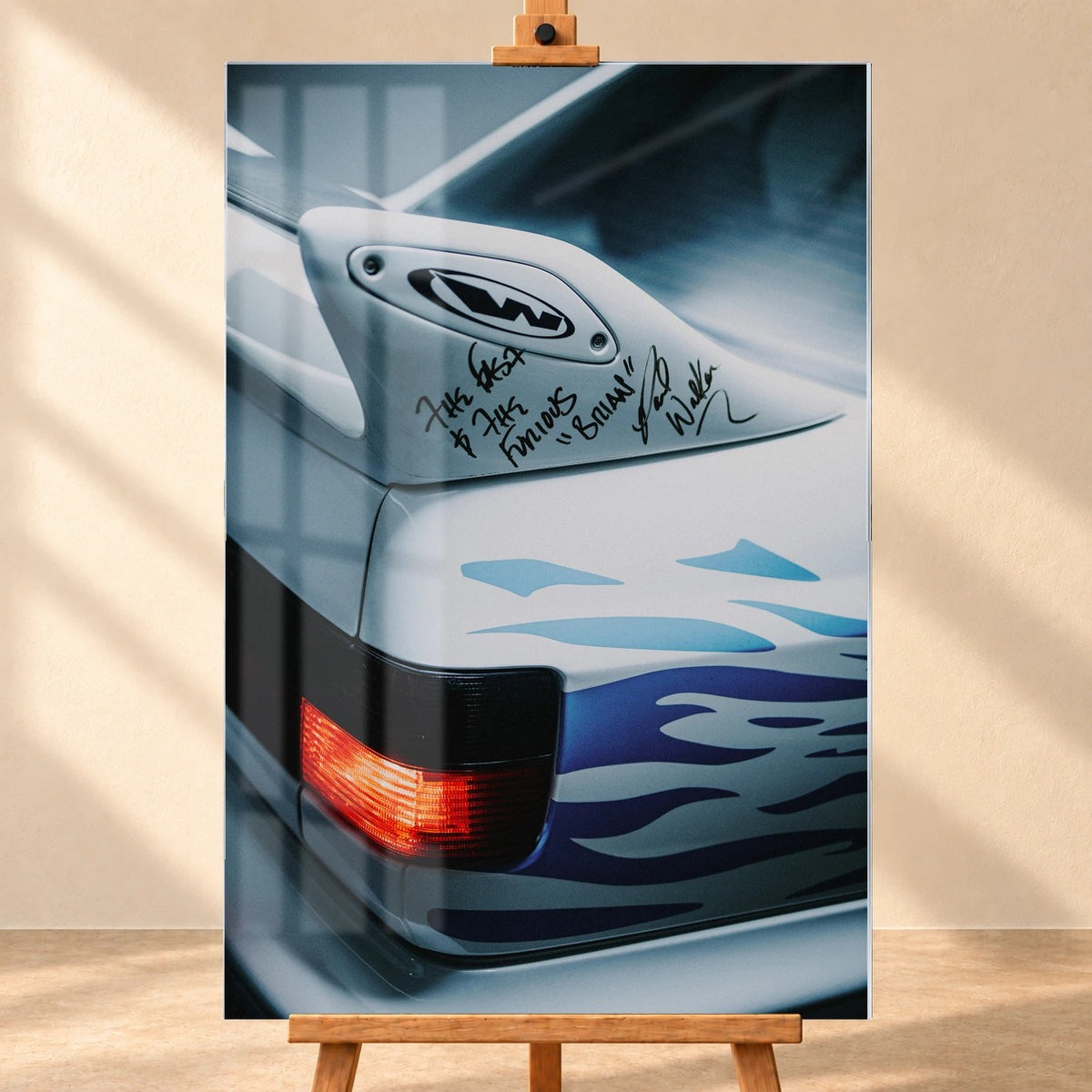 Frontal visualisiertes Acrylglasbild auf einer Holzstaffelei vor heller Wand. Dargestellte Fensterreflexe liegen über der Nahaufnahme von Jesses weißem VW Jetta mit handschriftlich beschriftetem Heckspoiler, blauen Flammen und roter Rückleuchte.