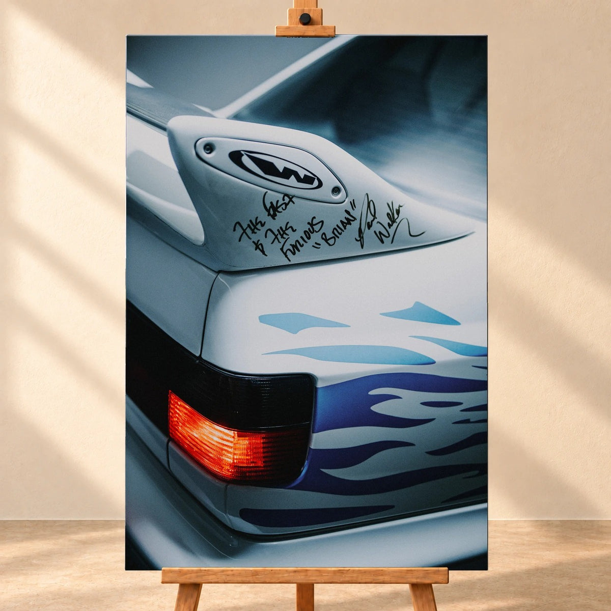 Visualisierung eines hochformatigen Leinwandbilds auf einer Holzstaffelei vor heller Wand. Das Motiv zeigt das Heck von Jesses weißem VW Jetta mit blauen Flammen, roter Rückleuchte und handschriftlich beschriftetem Heckspoiler.