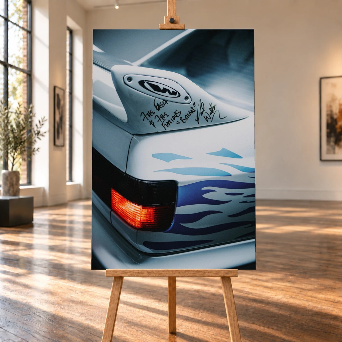 Raumvisualisierung mit einem hochformatigen Leinwandbild auf einer Holzstaffelei zwischen hohen Fenstern und Holzboden. Das Bild zeigt einen Heckausschnitt von Jesses weißem VW Jetta mit beschriftetem Spoiler, blauen Flammen und roter Rückleuchte.