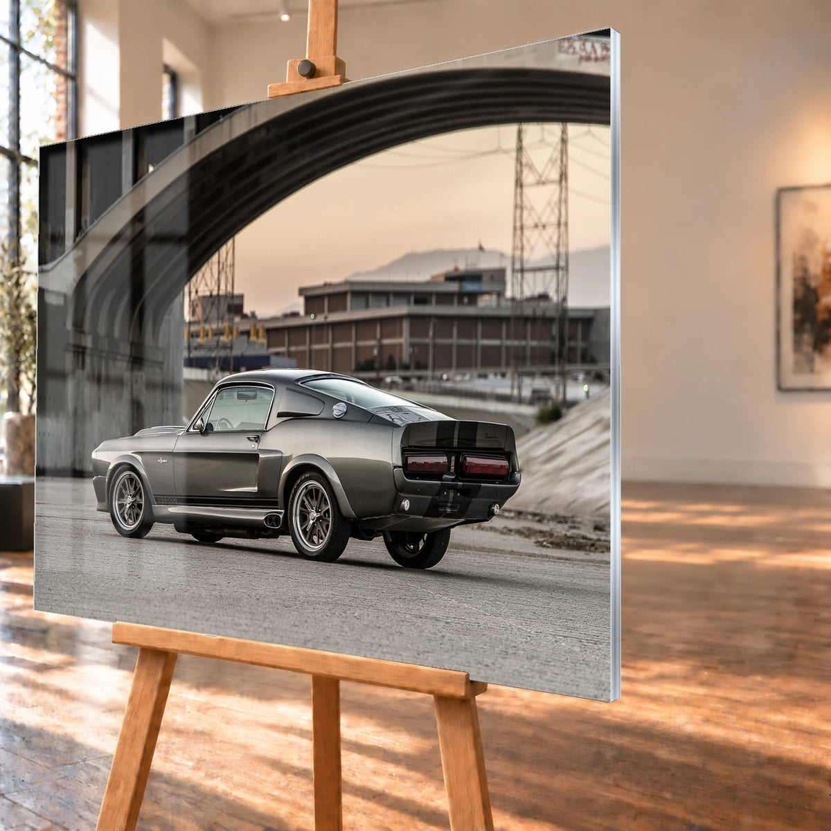 Eleanor steht im klaren Seitenprofil unter großen Betonbrücken; die Architektur bildet einen rauen urbanen Rahmen. Motiv „Hero Echo“ als Acrylglas-Wandbild, schräg von der Seite auf einer Holzstaffelei.