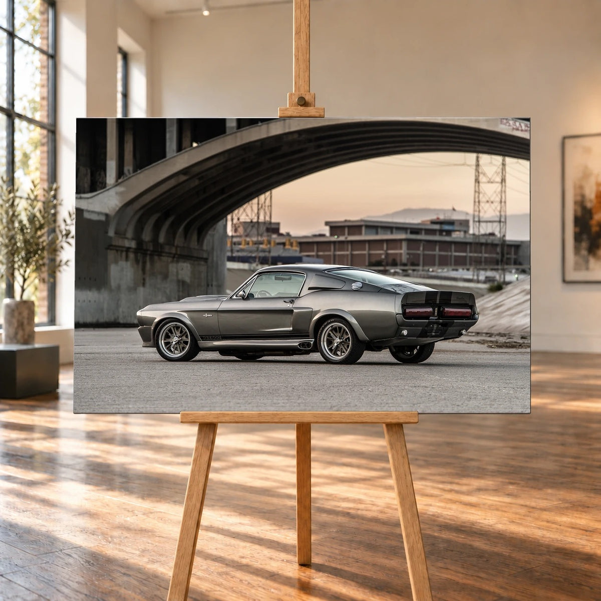 Eleanor steht im klaren Seitenprofil unter großen Betonbrücken; die Architektur bildet einen rauen urbanen Rahmen. Motiv „Hero Echo“ als Leinwand-Wandbild, auf einer Holzstaffelei in einem hellen Galerieraum.