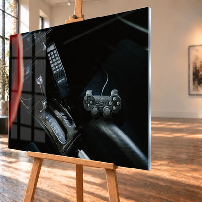 Die dunkle Cockpitaufnahme konzentriert sich auf Automatik-Wählhebel, Bedieneinheit und PlayStation-Controller. Motiv „Night Light“ als Acrylglas-Wandbild, schräg von der Seite auf einer Holzstaffelei.