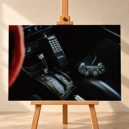 Die dunkle Cockpitaufnahme konzentriert sich auf Automatik-Wählhebel, Bedieneinheit und PlayStation-Controller. Motiv „Night Light“ als Leinwand-Wandbild, frontal auf einer Holzstaffelei.