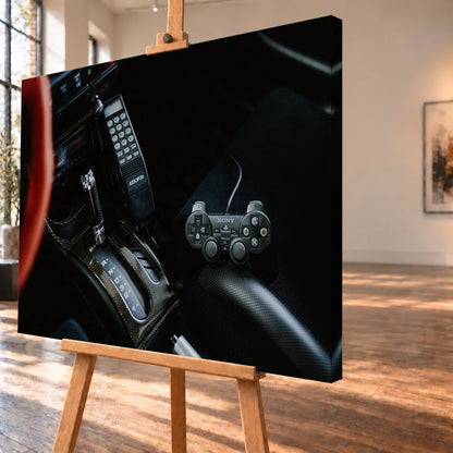 Die dunkle Cockpitaufnahme konzentriert sich auf Automatik-Wählhebel, Bedieneinheit und PlayStation-Controller. Motiv „Night Light“ als Leinwand-Wandbild, schräg von der Seite auf einer Holzstaffelei.