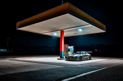 Der Mercedes SLS GT3 steht nachts allein unter dem Lichtdach einer Tankstelle; Rot, Blau und Orange gliedern die dunkle Szene. Originalmotiv „Apex Scene“ im Querformat.