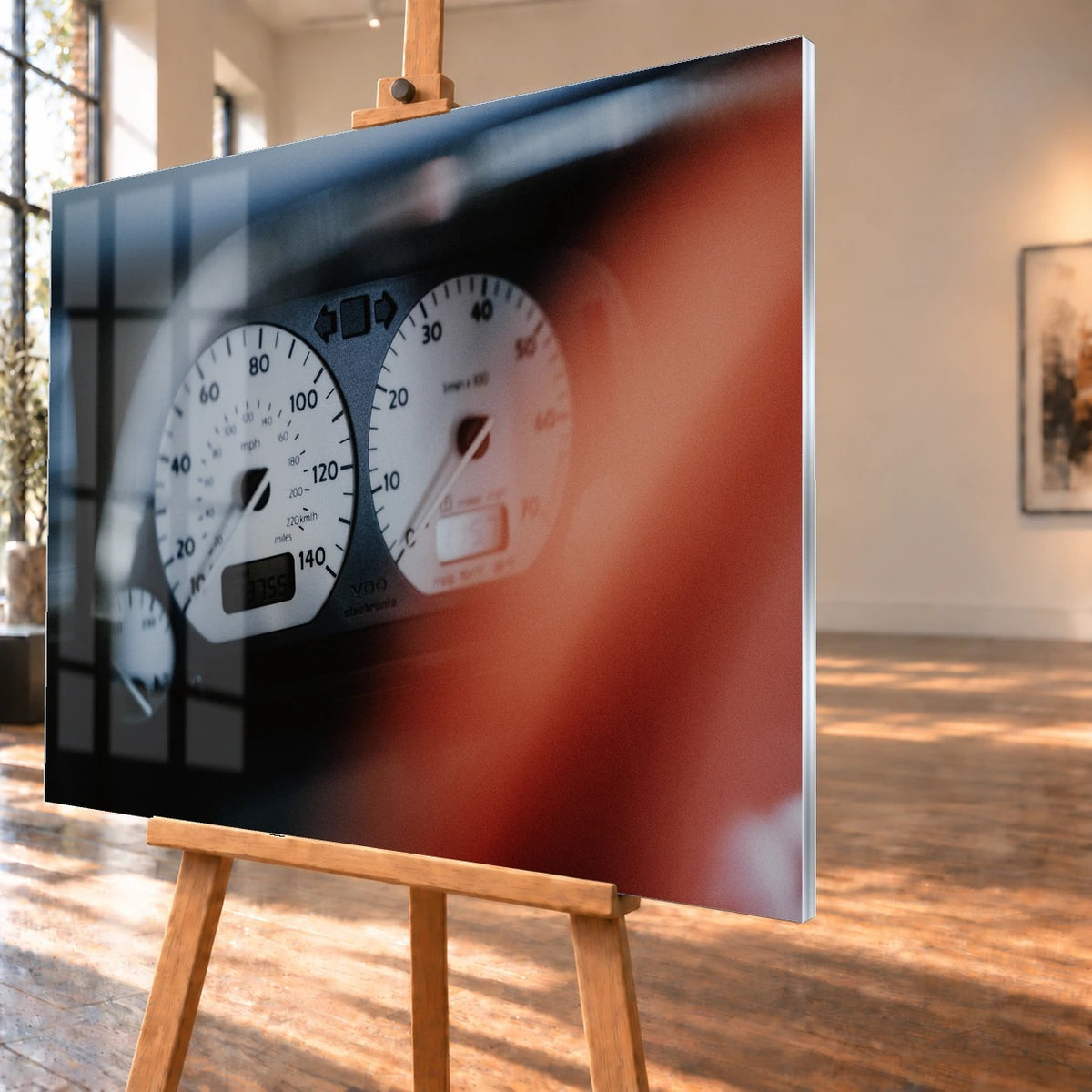 Weiße Rundinstrumente von Jesses Jetta sind eng fokussiert; rote Zeiger und dunkler Innenraum erzeugen starken Kontrast. Motiv „Road Presence“ als Acrylglas-Wandbild, schräg von der Seite auf einer Holzstaffelei.