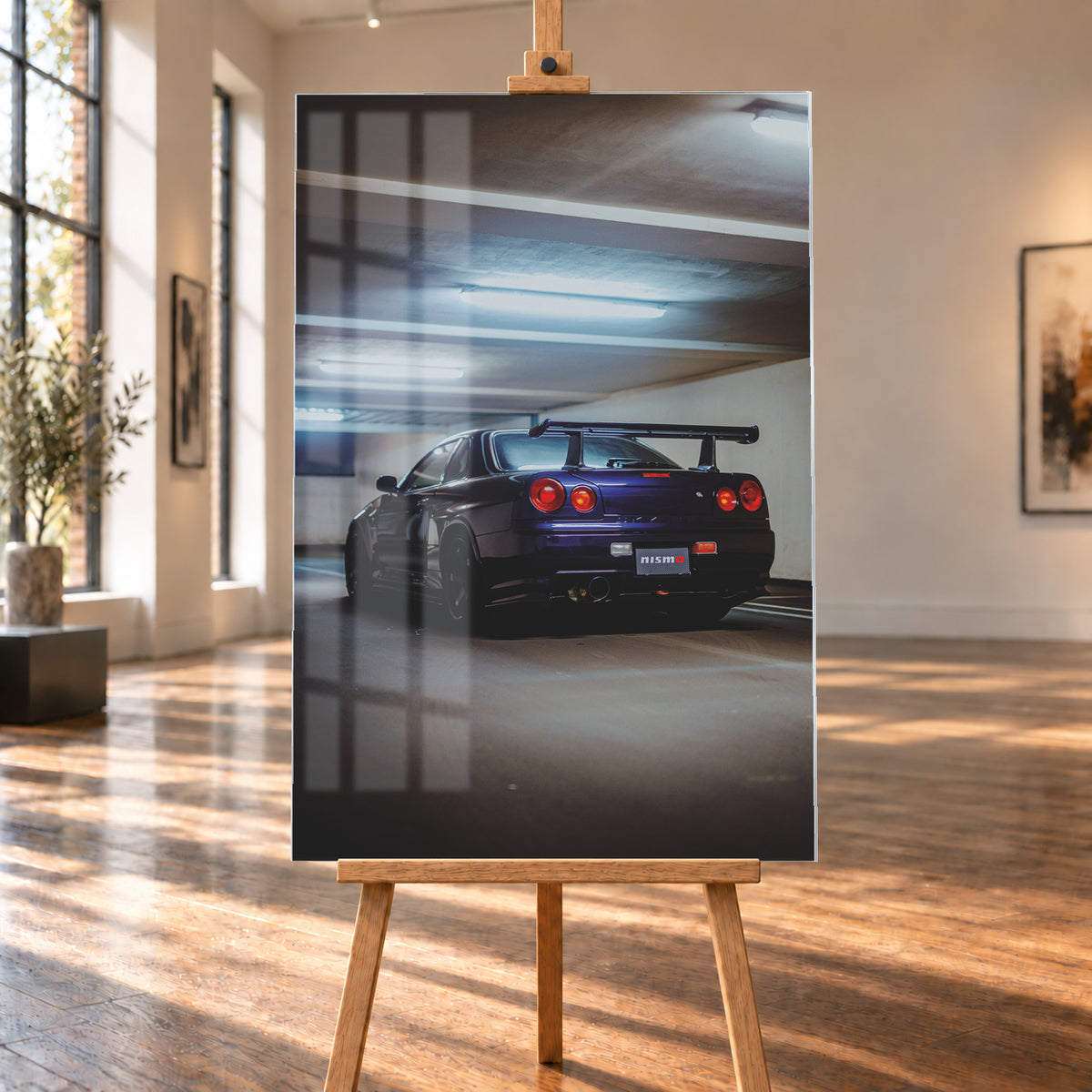 Dunkelvioletter Nissan Skyline R34 in tiefer Heckdreiviertelansicht in einem Parkhaus, mit vier runden roten Rückleuchten, großem Heckflügel, dunklen Rädern und kühlen Deckenleuchten; Visualisierung als Acrylglas-Wandbild, auf einer Holzstaffelei in einem hellen Galerieraum.