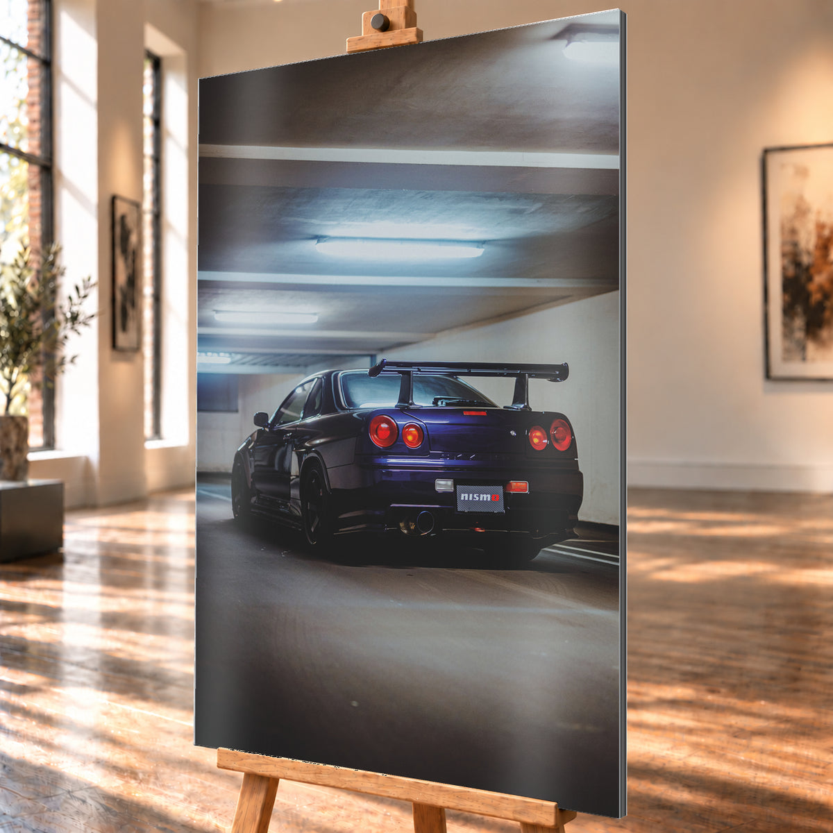Dunkelvioletter Nissan Skyline R34 in tiefer Heckdreiviertelansicht in einem Parkhaus, mit vier runden roten Rückleuchten, großem Heckflügel, dunklen Rädern und kühlen Deckenleuchten; Visualisierung als Alu gebürstet-Wandbild, schräg von der Seite auf einer Holzstaffelei.